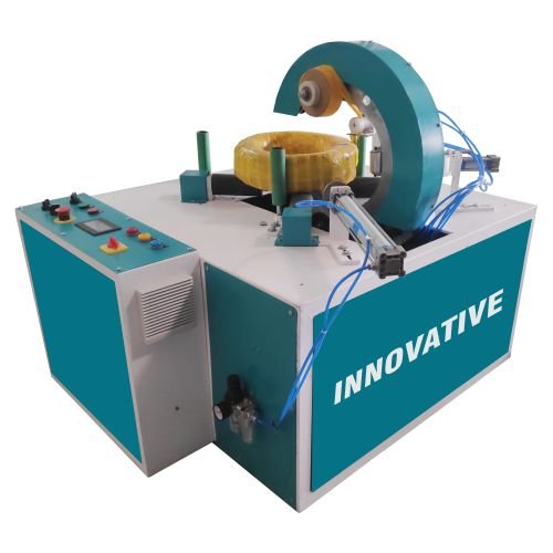 MS wire coil wrapping machine wrapping mild steel wire coils with stretch film in an industrial facility