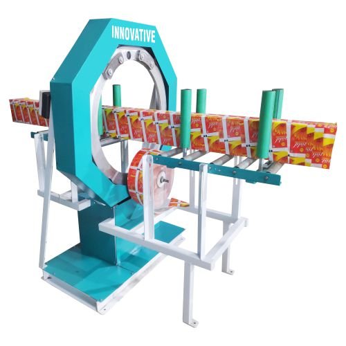 Small horizontal orbital stretch wrapper machine with a blue rotary ring and conveyor bed wrapping bundled aluminum extrusions in plastic stretch film.