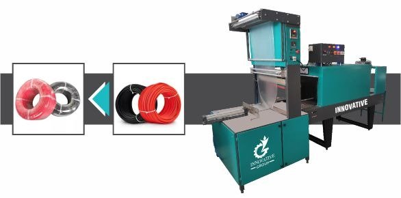 Shrink wrapping machine sealing MiG wire spools with heat shrink film for secure industrial packaging